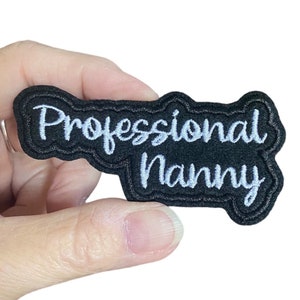 May include: Black iron-on patch with white embroidered text that reads "Professional Nanny".