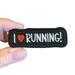 May include: Black embroidered patch with white text that says "I love running!" and a red heart.