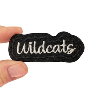 May include: Black felt patch with white embroidered text that reads "Wildcats".