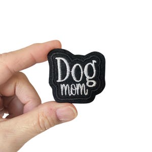 May include: Black embroidered patch with white text that reads "Dog mom".