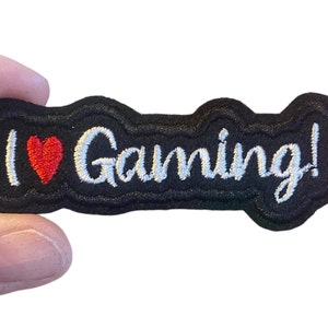 May include: Black embroidered patch with white text that says "I heart Gaming!" with a red heart.