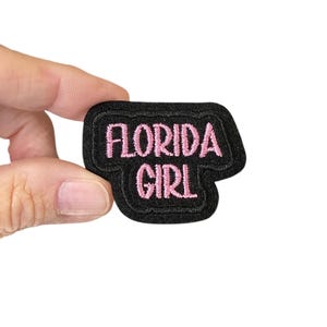 Peut inclure: Patch brodé noir avec inscription rose "Florida Girl".