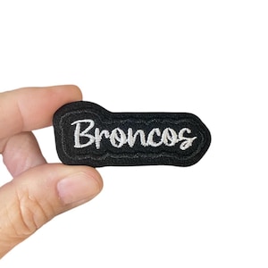 May include: Black embroidered patch with white lettering that says "Broncos".