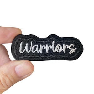 May include: Black embroidered patch with white lettering that reads "Warriors".