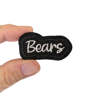 May include: Black embroidered patch with white cursive lettering that says "Bears".