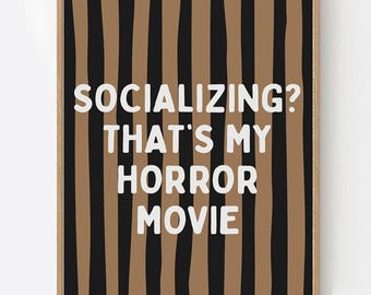 May include: A framed wall art print with a brown and black striped background. The white text reads "SOCIALIZING? THAT'S MY HORROR MOVIE." The bottom of the print says "BOHO HOME DECO BOUTIQUE."