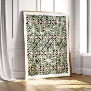 May include: A framed print featuring a repeating pattern of decorative tiles. The tiles have a floral design with green, blue, and yellow accents on a cream background. The frame is gold-colored and the print is leaning against a white wall.