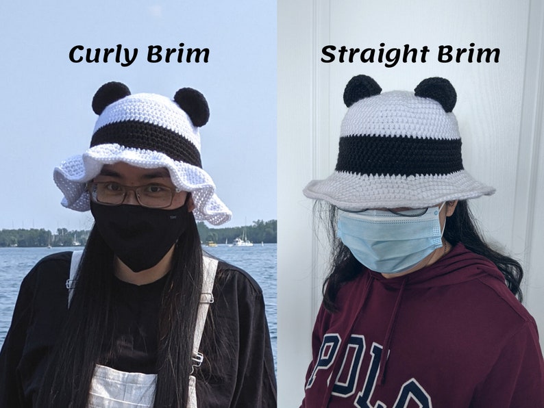 May include: Two crocheted bucket hats with panda ears. The hat on the left has a curly brim and the hat on the right has a straight brim. Both hats are white with a black stripe and black panda ears.