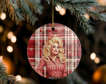 May include: Round Christmas ornament featuring a portrait of a woman with blonde hair and a red and white plaid shirt. The background is a red and white plaid pattern with snowflakes. The ornament hangs from a gold string.