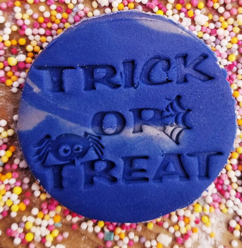 May include: A blue round cookie cutter with the words "Trick or Treat" and a spider design.
