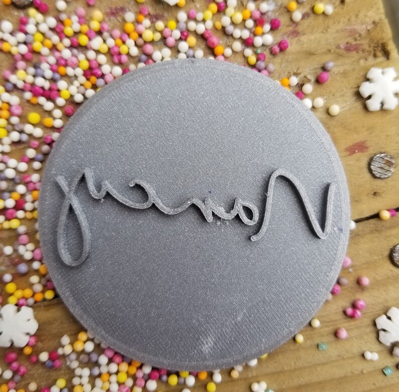 May include: A gray round cookie cutter with the word "Grandma" written in cursive.