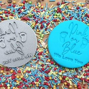 May include: Two round, blue and gray silicone stamps with the text "Pink or Blue We Love You" and two footprints.