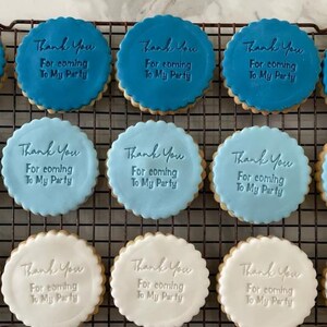 May include: Nine round cookies decorated with blue and white icing. Each cookie has the text "Thank You For coming To My Party" written on it.