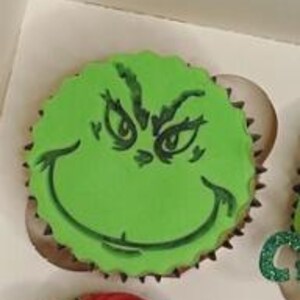 May include: Green cupcake with green frosting and a Grinch face design.