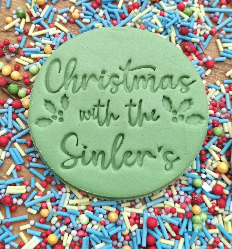 May include: Green round cookie cutter with the text "Christmas with the Sinler's" and a holly leaf design.