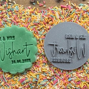 May include: Two stamps for wedding cookies. One is green, scalloped, and reads "MR & MRS Wishart 28.06.2025". The other is gray and circular, with the same name and date, and reads "MR & MRS Wishart 05.05.2025".