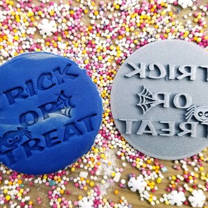 May include: Two blue and gray silicone stamps with the text "Trick or Treat" and a spider design.
