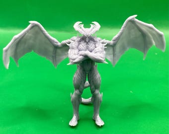May include: A light gray, unpainted resin figurine of a muscular, winged humanoid creature with large, curved horns. The figure stands with arms crossed over its chest, featuring detailed musculature, pointed ears, and expansive wings.