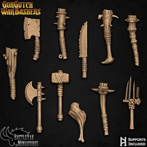 May include: A collection of miniature weapons, including axes, clubs, a knife, and a hammer, in a bronze color. The image features the text "Gurgutch War Bashers" and "BattleYak Miniatures". The phrase "Supports Included" is also visible.