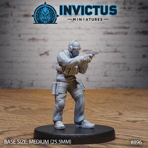 May include: A gray miniature figurine of a soldier aiming a handgun. The figure is wearing a tactical vest, knee pads, and a headset. The base is black, and the text "INVICTUS - MINIATURES" is visible. Base size: Medium (25.5mm).