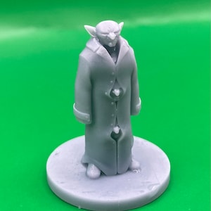 May include: A grey 3D printed miniature figurine of a goblin wearing a long coat with buttons. The figurine is standing on a round base.