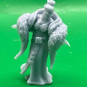 以下が含まれることがあります： 長いひげと毛皮の裏地が付いたマントを着た、灰色のローブ姿のフィギュア。フィギュアは帽子をかぶっており、腕を広げて立っています。このフィギュアは、ファンタジーのキャラクターまたはミニチュアである可能性があります。