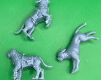 May include: Three grey plastic miniature dog figurines. The dogs are in different poses, one is standing on its hind legs, one is lying down, and one is jumping in the air.