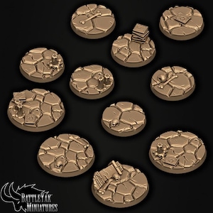 May include: A selection of brown, textured miniature bases with cracked earth patterns. Some bases feature small details like bones, books, and skulls. These bases are designed for tabletop gaming and miniature wargaming.
