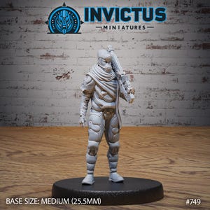 May include: A gray, detailed miniature figure of a person wearing a hooded, futuristic suit and holding a rifle. The figure is standing on a round base. The text "INVICTUS - MINIATURES -" is at the top of the image. The text "BASE SIZE: MEDIUM (25.5MM)" is at the bottom left of the image. The text "#749" is at the bottom right of the image.