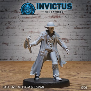 May include: A gray painted miniature figure of a person wearing a tattered coat and a hat, holding a pitchfork. The figure is standing on a round black base. The base is labeled "BASE SIZE: MEDIUM (25.5MM)" and "#526".