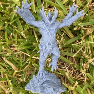 May include: A grey 3D printed miniature of a monstrous creature with sharp teeth and claws, standing on a rocky base.