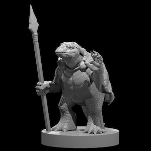 May include: A gray, detailed miniature figurine of a turtle-like creature holding a spear. The creature has a textured shell and is standing on a round base.