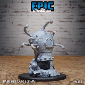 May include: A gray miniature figure of a mechanical creature with a round head, multiple tubes, and a spiked base. The figure is mounted on a black base. The text "EPIC Miniatures" is at the top. The base size is large (51mm).