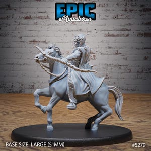 May include: A grey, unpainted miniature of a figure riding a horse. The figure is wearing a hooded cloak and holding a bow and arrow. The base is large, measuring 51mm. The miniature is labelled "#5279".