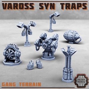 May include: A collection of gray miniature sci-fi terrain pieces, including towers, turrets, and cylindrical structures. The text "VAROSS SYN TRAPS" and "GANG TERRAIN" are visible. These pieces are designed for tabletop gaming.