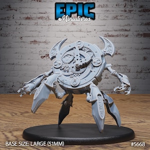 Könnte beinhalten: Hellgrauer Miniaturroboter mit uhrähnlichem Körper und mechanischen Gliedmaßen. Der Roboter steht auf einem schwarzen Sockel. Der Text "EPIC Miniatures" steht oben. Sockelgröße: groß (5,1 cm).