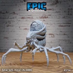 May include: A light grey miniature figure of a monstrous creature with a humanoid face, long flowing hair, and multiple spider-like legs. The figure has a large, bulbous head and is labeled "EPIC Miniatures". The base size is listed as Huge (7.65cm).