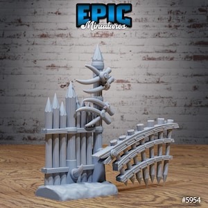 May include: A gray miniature fantasy structure with a fence, tower, and bridge elements. The tower has decorative horns and a pointed top. The fence has pointed tops. The bridge is curved with pointed posts. The text "EPIC Miniatures" is at the top.