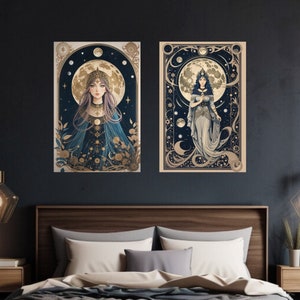 May include: Two framed art prints with a celestial theme. Each print features a woman in a flowing gown standing in front of a crescent moon. The background is a dark blue with gold stars and swirls.