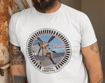 May include: White t-shirt with a circular graphic of a pin-up girl sitting on a plane with the text "Tight Formation" and "Warbird Pinup Girls".