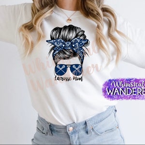May include: White sweatshirt with a graphic of a woman with a messy bun, sunglasses, and lacrosse sticks. The text "Lacrosse Mom" is below the graphic. The text "Whimsical Wanderer" is in the bottom right corner.