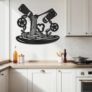 May include: Black metal wall art depicting a plate of spaghetti with salt and pepper shakers pouring over the noodles. The art is mounted on a white wall in a kitchen setting.