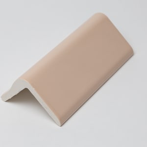 May include: A light pink ceramic corner trim tile with a rounded edge.