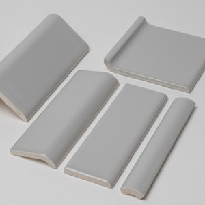 May include: Set of five gray ceramic tile trim pieces with rounded edges. The trim pieces are in various shapes and sizes.