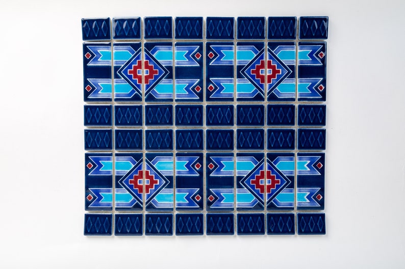 Puede incluir: Una hoja de mosaico azul y blanco con un patr&oacute;n geom&eacute;trico en rojo y azul. El patr&oacute;n presenta una forma de diamante con una cruz en su interior y una serie de l&iacute;neas horizontales.