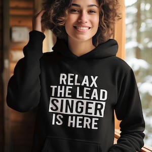 May include: Black hoodie with white text that reads "Relax the Lead Singer is Here".