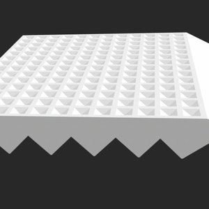 May include: White sound-absorbing foam panel with a pyramid pattern on the top surface and a jagged edge on the bottom. The panel is angled to create a ramp.