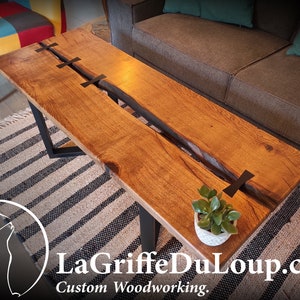 Solid oak coffee table with inverted live edge edges and ebony butterflies.
