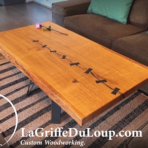 Single-piece live-edge oak coffee table with ebony farandole.