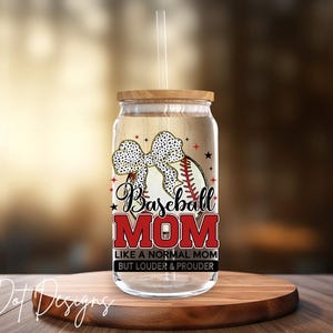 May include: A clear glass tumbler with a wooden lid and straw. The tumbler features a baseball design with a bow and the words "Baseball MOM" in red and white. The text below reads "LIKE A NORMAL MOM BUT LOUDER & PROUDER."